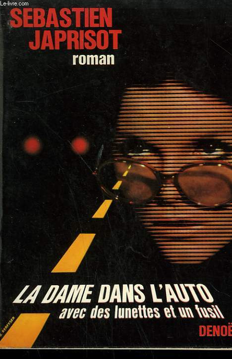 LA DAME DANS L'AUTO AVEC DES LUNETTES ET UN FUSIL.