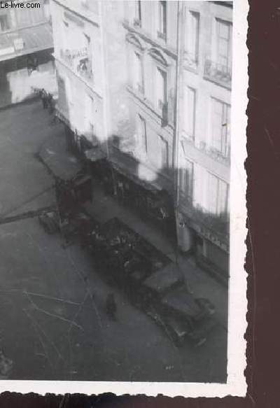 1 PHOTO ARGENTIQUE EN NOIR ET BLANC DE DIMENSION : 7 X 10 Cm : CHUTE D'UN BOMBARDIER AVRO LANCASTER SUR LES MAGASINS DU LOUVRES ET DE SES ENVIRONS A PARIS : VUE SUR LA RUE AVEC MATERIEL MILITAIRE.